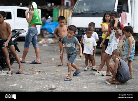 A Group Of Young Filipino Children Play A Game Together In The Street