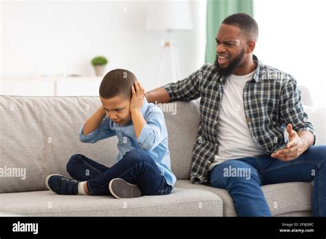 Angry Black Dad Shouting At Unhappy Son Sitting At Home Stock Photo Alamy