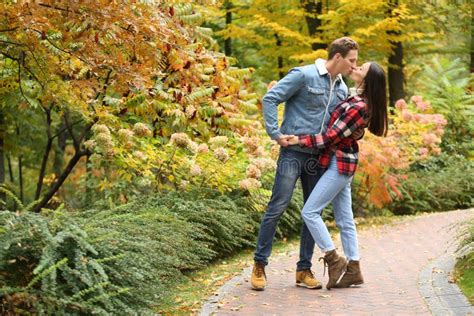 Loving Young Couple Kissing On Romantic Date In Autumn Park Stock Photo