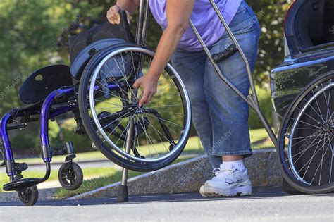 Woman Using Crutches To Set Wheelchair Stock Image F0124419