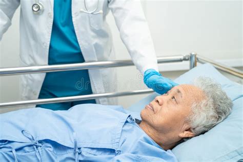 Doctor Checking Senior Or Elderly Old Lady Woman Patient Lie Down In Nursing Hospital Ward