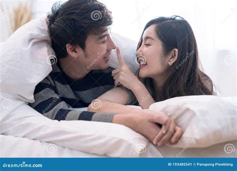 happy asia couple teasing each other on the bed in the bedroom stock image image of couple