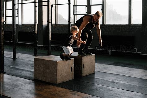 Man And Boy Jumping From Boxes In Gym By Stocksy Contributor Alina