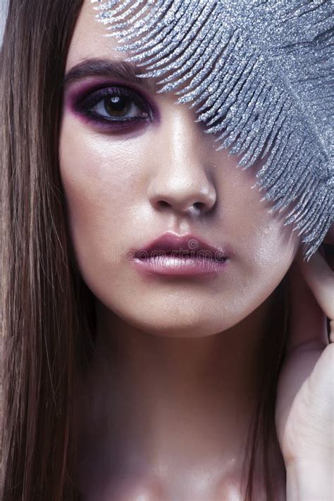 Beauty Brunette Young Girl With Fashion Makeup And Silver Feather