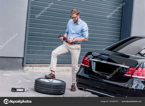 Man Changing Car Tire Stock Photo ArturVerkhovetskiy