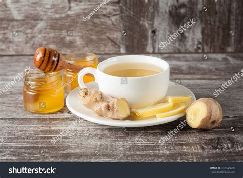 A White Cup Of Green Natural Tea With Ginger Lemon And
