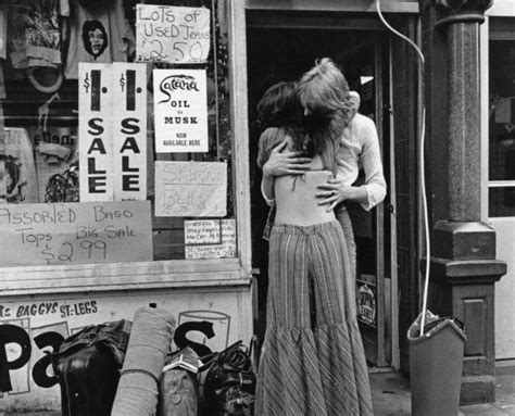 A Hippie Couple Embrace Outside A Shop Selling Second Hand Clothes In