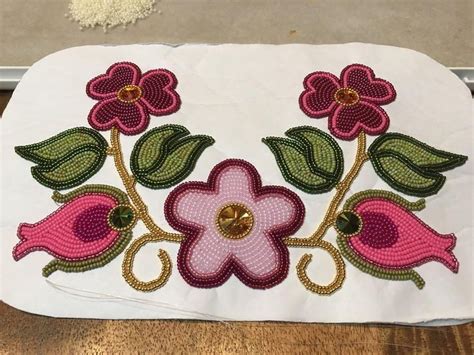 A White Piece Of Cloth With Flowers And Leaves On It Sitting On A Table