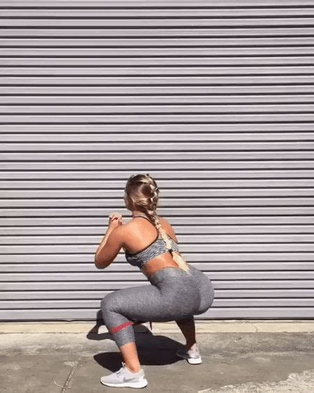 A Woman Squatting On The Ground In Front Of A Garage Door