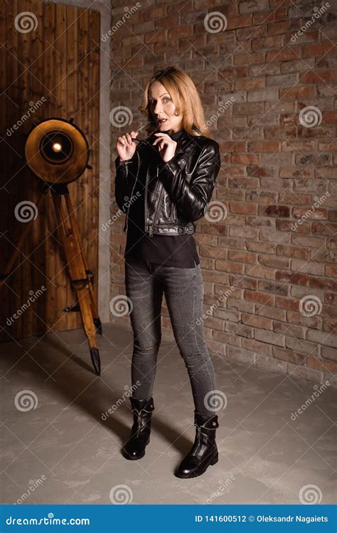 Fashion Model In A Black Leather Jacket Posing Near Brick Wall Stock