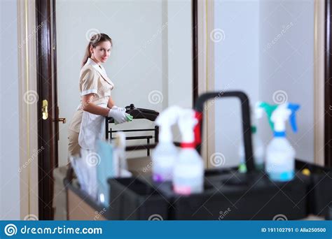 Room Servicea Uniformed Maid Cleans The Roommaid`s Cart With Work