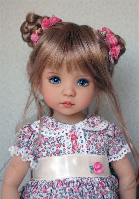 a doll with blonde hair and blue eyes is wearing a pink flowered dress in front of a white wall