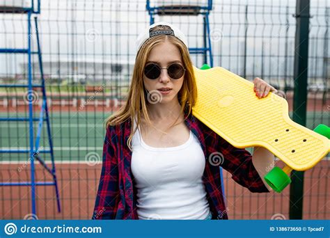 A Pretty Blond Girl Wearing Checkered Shirt White Cap And Sunglasses