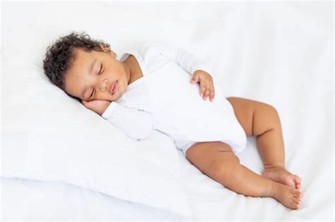 Premium Photo African American Little Baby Sleeps On A White Bed At