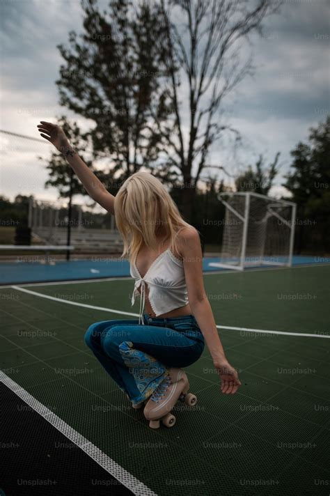 A Woman Riding A Skateboard On Top Of A Tennis Court Photo Roller
