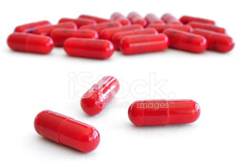 Three Red Pills Capsules With Many In Background Stock Photos