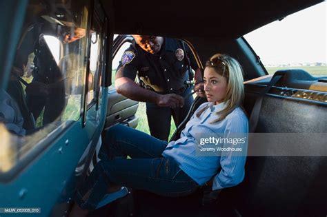 Mid Adult Woman Arrested By A Police Officer Sitting In A Police Car