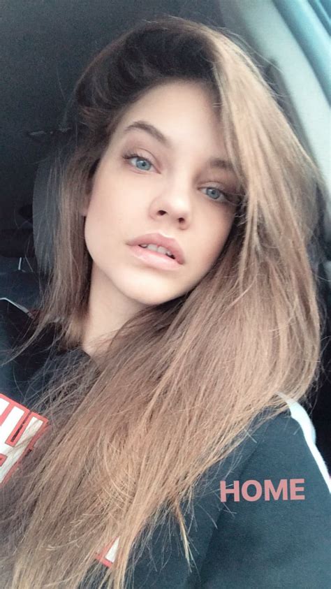 A Woman Sitting In The Back Seat Of A Car With Long Hair And Blue Eyes