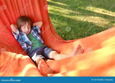 Cute Little Boy Relaxing In Hammock On Sunny Day Outdoors Stock Photo