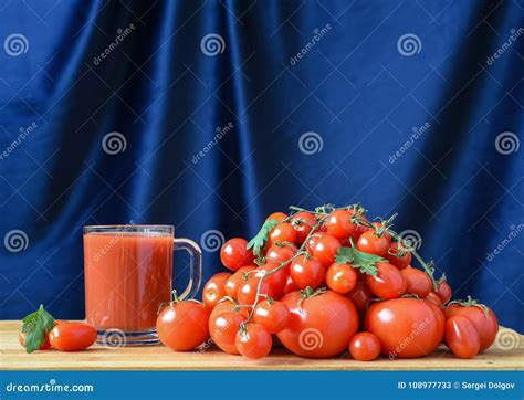 Still Life With Tomato Juice In Glass And Fresh Tomatoes On Wooden