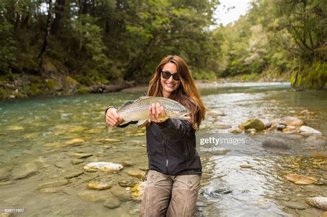 Caucasian Woman Catching Fish In Remote River Stock Foto Getty Images