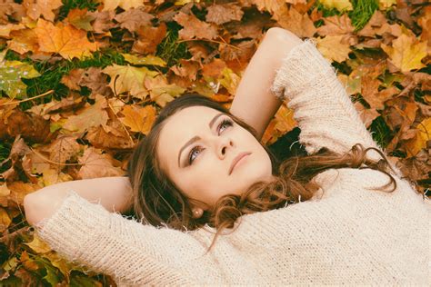 Free Photo Woman In Sweater Laying On Dried Maple Leaves Autumn