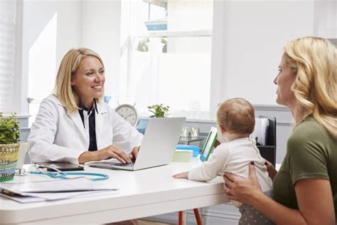 Mother And Baby Meeting With Female Doctor In Office Stock Image