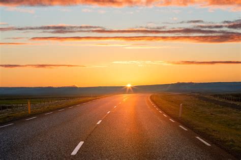 Scenic View Of Sunset Over Country Road Stock Photo