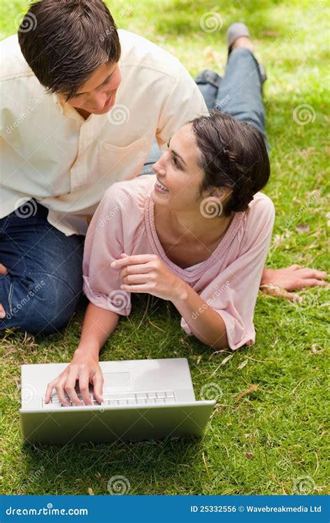 Two Friends Looking At Each Other As They Are Lying Down Stock Photo
