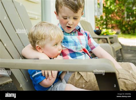 Older Brother Puts Arm Around Younger Brother While Talking To Him