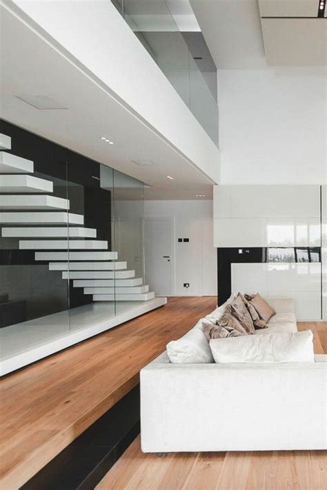 A White Couch Sitting In The Middle Of A Living Room Next To A Stair Case