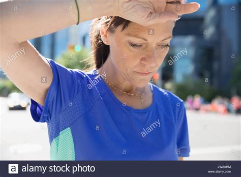 Close Up Tired Mature Female Runner Wiping Sweat From Forehead Stock