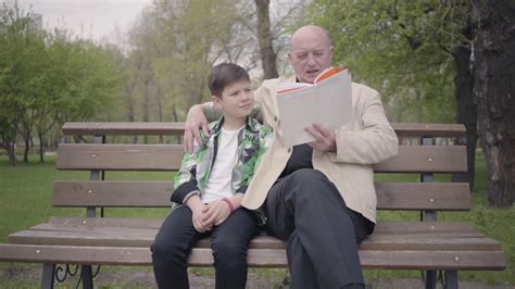 Grandfather Grandson Sitting In Park On Stock Footage Sbv 335297331