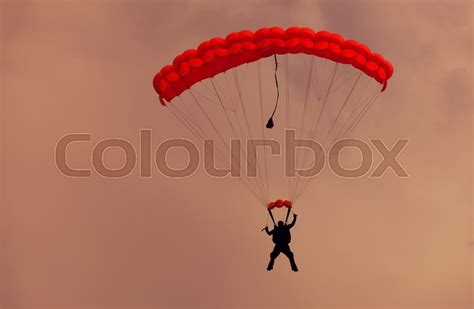 Male Parachutist Makes The Jump From The Plane On A Red Parachute