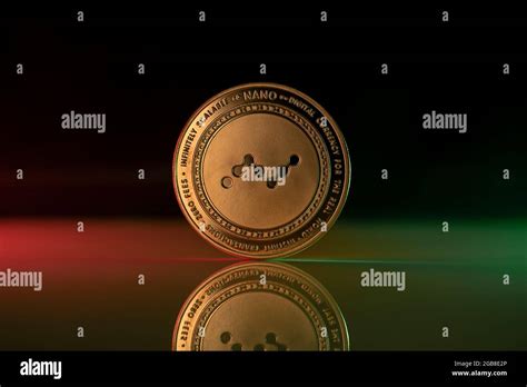 Nano Cryptocurrency Physical Coin Placed On Reflective Surface And Lit With Green And Red Lights