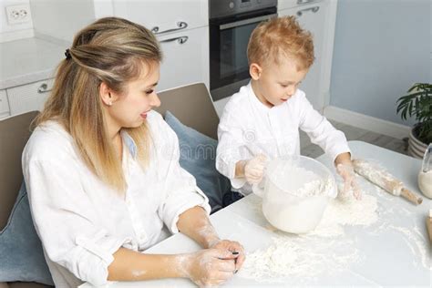 Maman Et Son Fils Cuisinent Ensemble Dans Une Cuisine Blanche à Partir De Pâte Photo Stock