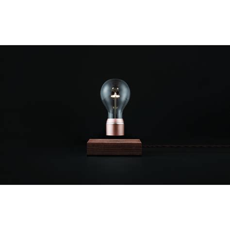 L'ampoule vole au dessus d'un bloc de bois, un design minimaliste et surprenant ! Lampe de Table Flyte - Milano Design Store
