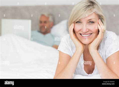 Happy Mature Woman With Man Using Laptop In Bed Stock Photo Alamy
