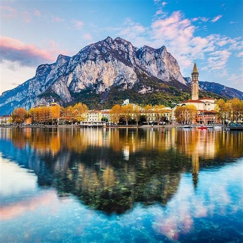 The Mountains Are Reflected In The Still Water Of Lake Luganoni Italy