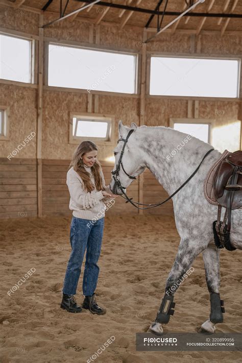 Woman With Dapple Gray Horse With Long Fluffy Tail Walking Around Light