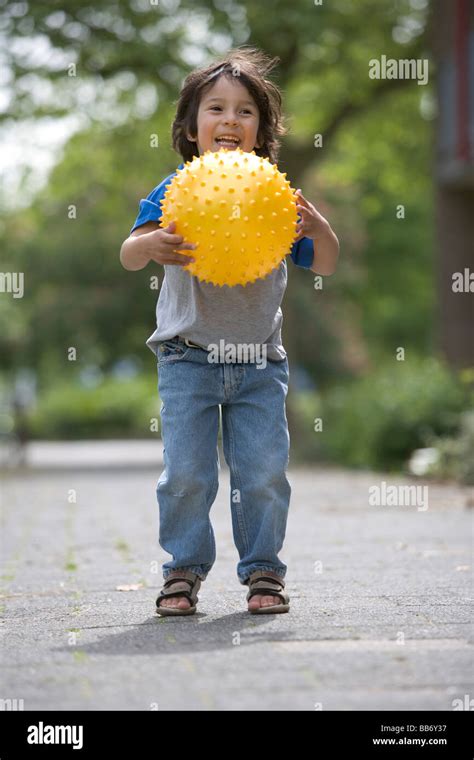 Little Boy Catching A Yellow Ball Stock Photo Alamy
