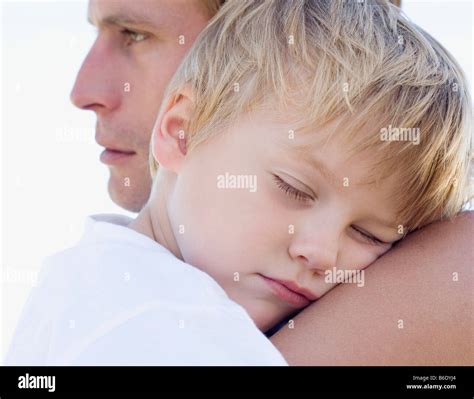 Father Cuddling His Sleeping Son Stock Photo Alamy