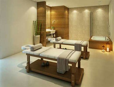 A Spa Room With Two Massage Tables And Towels On The Back Of Each Table