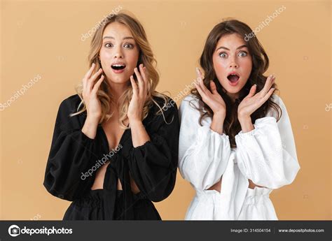 Portrait Of Two Shocked Women Looking At Camera With Throwing Up Hands