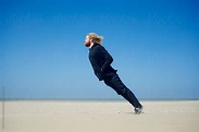 Young man ready for what is coming. Leaning into the strong wind on the ...