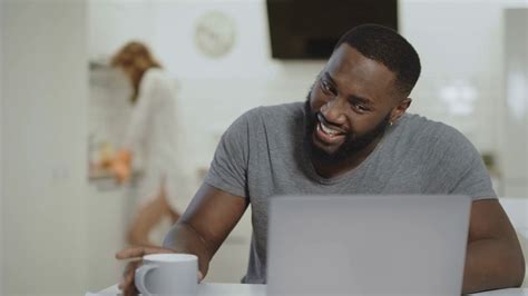 Laughing Black Man Drinking Tea At Open Kitchen Young African Guy