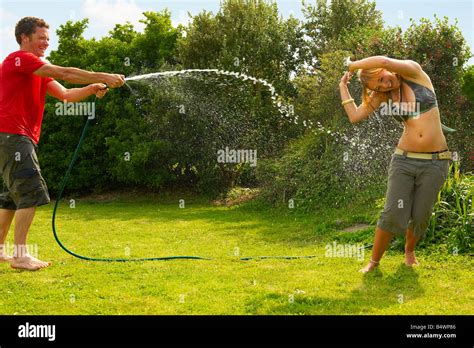 mann frau mit gartenschlauch spritzen stockfotografie alamy