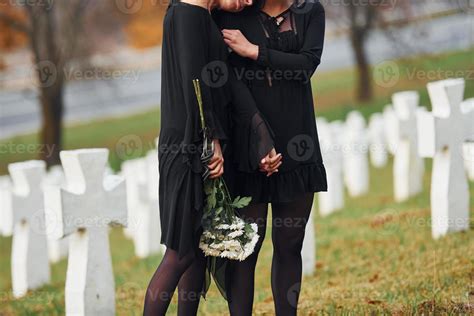 Embracing each other and crying. Two young women in black clothes