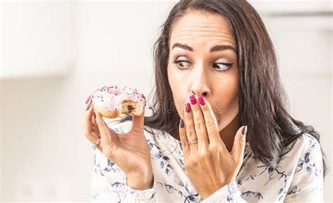 Oops Expression On A Face Of A Woman Who Has Bitten Into A Donut In Her Hand Stock Image Image