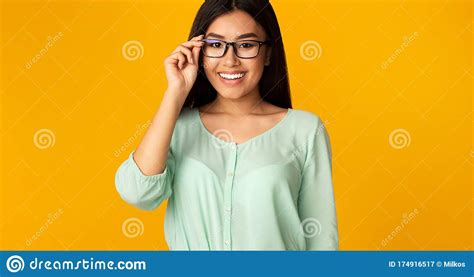 asian girl in eyeglasses posing smiling to camera yellow background stock image image of